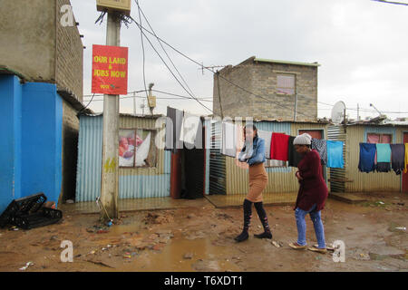 Johannesburg, Südafrika. 22 Apr, 2019. 1470 - Maulein Dikobo, rechts, und ihrem Freund gehen durch das Township von Johannesburg Alexandra. Dikobo sagt, daß sie nicht in Südafrika Wahlen nicht am 8. Mai abstimmen. (Dpa' für das Jubiläum Es ist ein Kater Stimmung: Südafrika wählt neues Parlament" am 03.05.2019) Credit: Kate Bartlett/dpa/Alamy leben Nachrichten Stockfoto