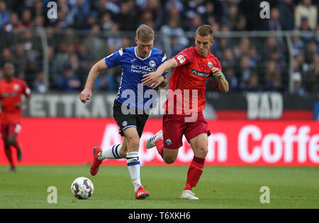 Bielefeld, Deutschland. 03 Mai, 2019. 2. Fussball Bundesliga, Arminia Bielefeld - SC Paderborn 07 32. Spieltag in der Schüco Arena. Der Bielefelder Fabian Klos (l) im Kampf um den Ball mit Uwe Hünemeier (r) aus Paderborn. Credit: Friso Gentsch/dpa - WICHTIGER HINWEIS: In Übereinstimmung mit den Anforderungen der DFL Deutsche Fußball Liga oder der DFB Deutscher Fußball-Bund ist es untersagt, zu verwenden oder verwendet Fotos im Stadion und/oder das Spiel in Form von Bildern und/oder Videos - wie Foto Sequenzen getroffen haben./dpa/Alamy leben Nachrichten Stockfoto