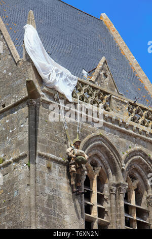 Kirche mit Fallschirm Denkmal am Sainte-Mere-Eglise, wo John Steele von der 505th Parachute Infantry Regiment erhielt am D-Day in der Normandie, Frankreich klemmt Stockfoto