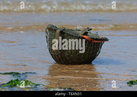 Eine olive-grün M1 Bekämpfung der Helm der US-Armee bei Omaha Beach in der Normandie, Frankreich Stockfoto