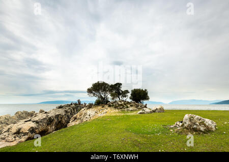 Bäume und Felsen in der Nähe der kleinen Bucht von Sveti Blaz (Insel Cres, Kroatien) an einem bewölkten Tag im Frühling Stockfoto