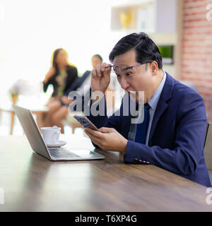 Asiatische Geschäftsmann Feiern im Cafe Stockfoto