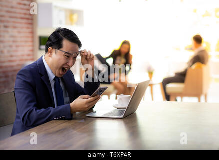 Asiatische Geschäftsmann Feiern im Cafe Stockfoto