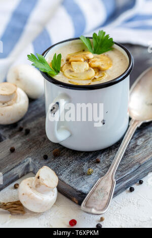 Creme - Suppe mit Champignons in einem Emaille Tasse. Stockfoto