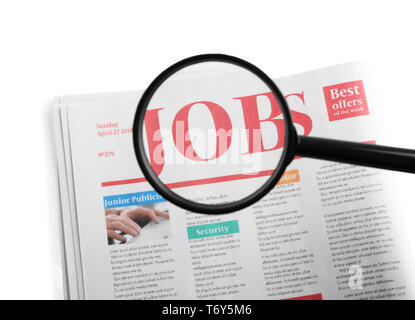 Lupe und Zeitung mit Überschrift Jobs auf weißem Hintergrund Stockfoto
