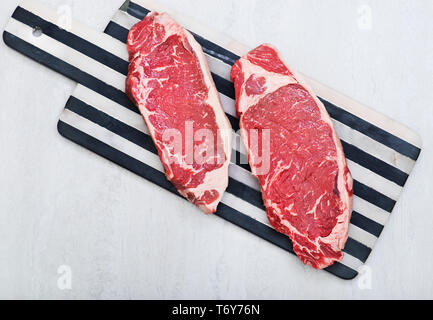 Raw New York Strip Steak auf einem Schneidebrett Stockfoto