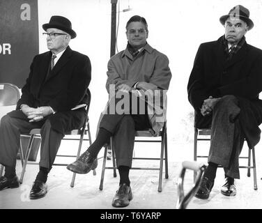 Drei Männer (von links nach rechts, Illinois Kongreßabgeordneten Melvin Preis, Fermilab Regisseur Robert Wilson, und Chemiker Glenn Seaborg) sitzen auf Klappstühlen auf einem Lautsprecher ' Plattform, Batavia, Illinois, 1968. Mit freundlicher Genehmigung des US-Ministeriums für Energie. () Stockfoto