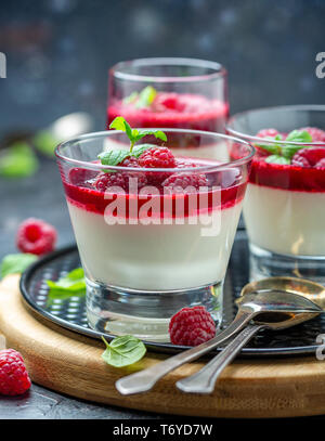 Vanille Panna Cotta mit Beeren Sauce und Himbeere. Stockfoto