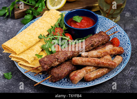 Türkisch und Arabisch traditionellen Ramadan mix Kebab Platte. Kebap Adana, Lamm und Rind auf lavash Brot mit Tomatensauce. Stockfoto