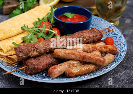 Türkisch und Arabisch traditionellen Ramadan mix Kebab Platte. Kebap Adana, Lamm und Rind auf lavash Brot mit Tomatensauce. Stockfoto