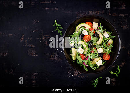 Grüner Salat mit Avocado in Scheiben, Tomaten, schwarze Oliven und Käse. Gesunde Ernährung Vegetarische Sommer Gemüse Salat. Tabelle einstellen. Essen Konzept Stockfoto