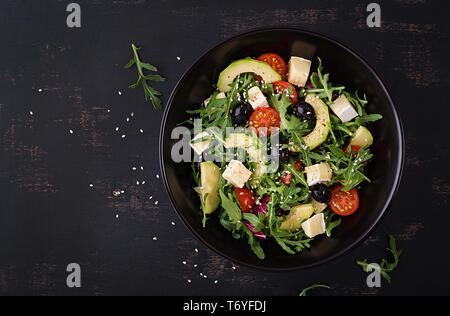 Grüner Salat mit Avocado in Scheiben, Tomaten, schwarze Oliven und Käse. Gesunde Ernährung Vegetarische Sommer Gemüse Salat. Tabelle einstellen. Essen Konzept Stockfoto