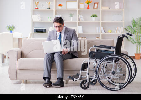 Dsabled Geschäftsmann auf Rollstuhl arbeiten Home Stockfoto