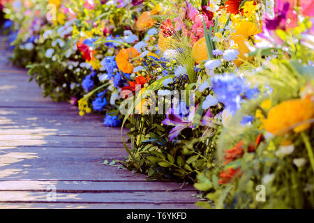 Einen sehr rustikalen Holzbrücke durch extrem bunte Blumenarrangements begrenzt Stockfoto