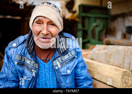 Portrait von Peruanischen alte Mann sitzt auf Holzbalken, Paucartambo, Peru Stockfoto