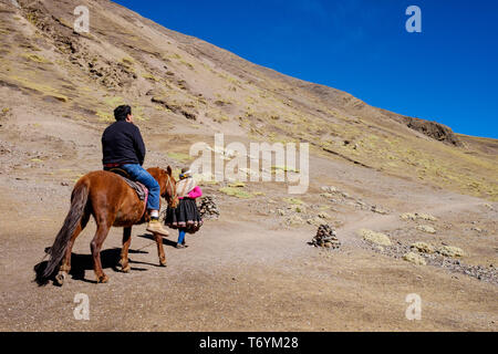 Touristen ein Pferd reiten zu den eindrucksvollen Rainbow Berg in Los Andes von Peru zu erhalten Stockfoto