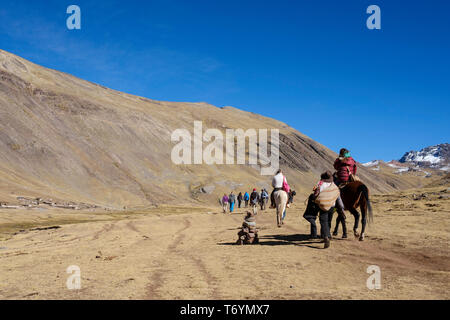 Touristen ein Pferd reiten zu den eindrucksvollen Rainbow Berg in Los Andes von Peru zu erhalten Stockfoto