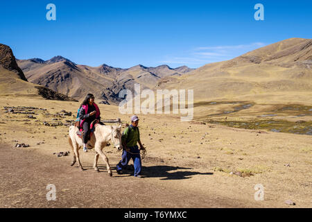 Touristen ein Pferd reiten zu den eindrucksvollen Rainbow Berg in Los Andes von Peru zu erhalten Stockfoto