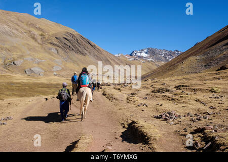 Touristen ein Pferd reiten zu den eindrucksvollen Rainbow Berg in Los Andes von Peru zu erhalten Stockfoto