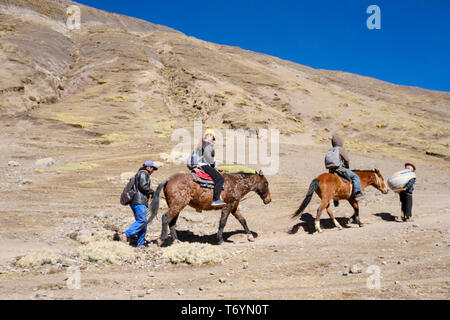 Touristen ein Pferd reiten zu den eindrucksvollen Rainbow Berg in Los Andes von Peru zu erhalten Stockfoto