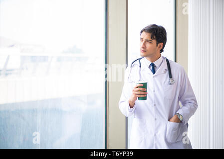 Jungen gutaussehenden Arzt steht am Fenster Stockfoto