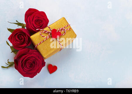 Rote Rosen und goldenen Geschenkkarton Stockfoto