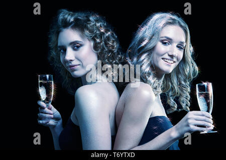 Zwei Mädchen mit einem Glas Champagner in der Hand Stockfoto