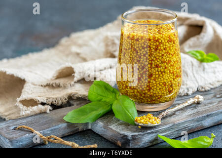 Senf Sauce im Glas und frischem Basilikum. Stockfoto