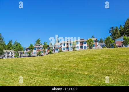 Reihe von Stadthäusern auf der Spitze des Hügels an einem sonnigen Tag in British Columbia. Stockfoto