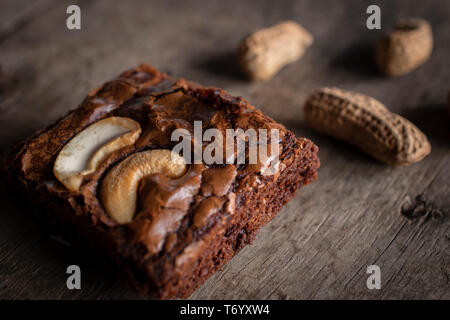 Brownie mit topping Cashewnuss und Erdnüsse auf der Rückseite. Sie setzen sich auf einem hölzernen Schreibtisch. Stockfoto