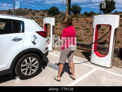 Frau Kraftfahrer Vorbereitung batterie Elektrofahrzeug in Gundagai in New South Wales, Australien zu berechnen Stockfoto