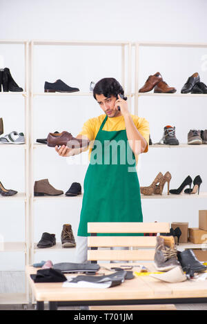 Junger Mann Schuhe, Reparatur in Werkstatt Stockfoto