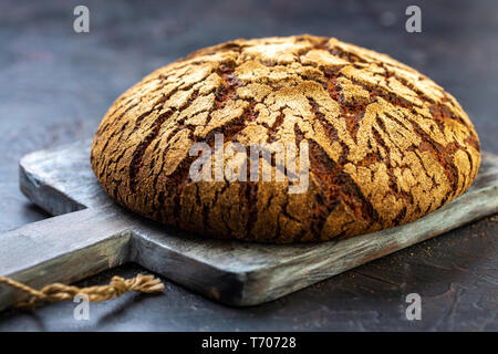 Handwerkliche finnische Roggenbrot auf einem Holzbrett. Stockfoto