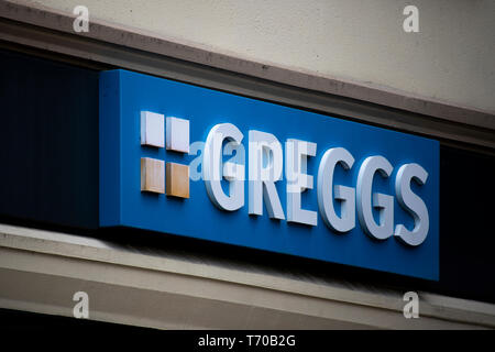 Greggs Schild über Einzelhandelsflächen, größte Bäckereikette in Großbritannien, Produkte gehören backt, Sandwiches und süßen Speisen mit Donuts Stockfoto