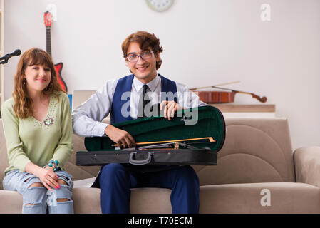 Junge Frau während der musikstunde mit männlichen Lehrer Stockfoto