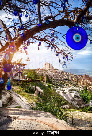 Burg Uchisar bei Sonnenuntergang und Baum mit traditionellen türkischen Augen Amulette in Kappadokien Stockfoto