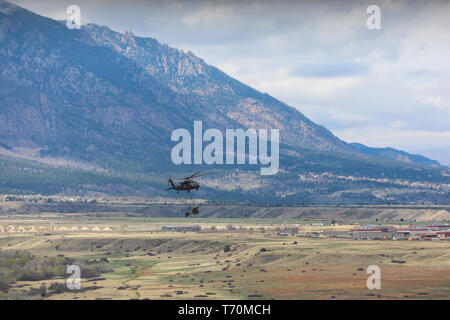 Ein UH-60 Black Hawk, die von Mitgliedern des 4 Combat Aviation Brigade pilotiert, 4 Infanterie Division, wählt einen M119 Haubitze, 2. Mai 2019, während Air Assault Training mit Soldaten Bravo. Akku, 2. Battalion, 77th Field Artillery Regiment, 2 Infantry Brigade Combat Team, 4. Inf. Div., auf Fort Carson, Colorado. (U.S. Armee Foto: Staff Sgt. Neysa Canfield) Stockfoto