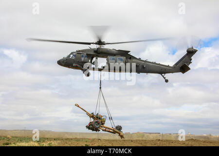 Ein UH-60 Black Hawk, die von Mitgliedern des 4 Combat Aviation Brigade pilotiert, 4 Infanterie Division, wählt einen M119 Haubitze, 2. Mai 2019, während Air Assault Training mit Soldaten Bravo. Akku, 2. Battalion, 77th Field Artillery Regiment, 2 Infantry Brigade Combat Team, 4. Inf. Div., auf Fort Carson, Colorado. (U.S. Armee Foto: Staff Sgt. Neysa Canfield) Stockfoto