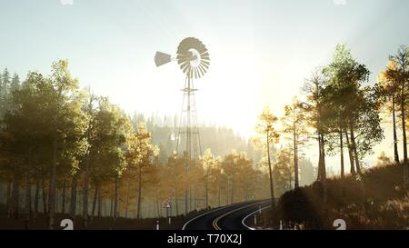 Typische alte Windmühle Turbine im Wald bei Sonnenuntergang Stockfoto