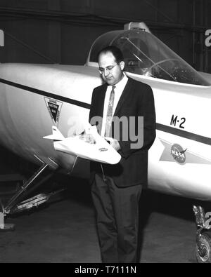 NASA-Ingenieur Dale Reed, hält ein Modell der M2-F1 Heben Körper Flugzeuge mit der vollen Version hinter ihm, 6. März 1967. Mit freundlicher Genehmigung der Nationalen Luft- und Raumfahrtbehörde (NASA). () Stockfoto