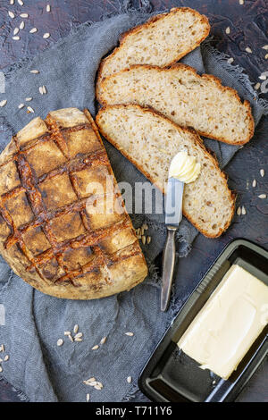 Handwerkliche Rustikales Brot geschnitten und Butter. Stockfoto