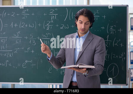 Junge schöne Mathematik Lehrer im Klassenzimmer Stockfoto