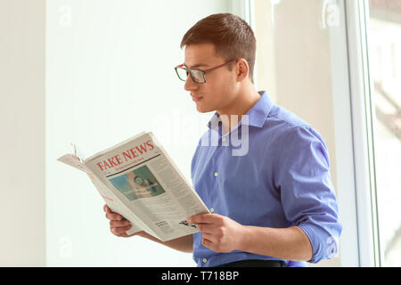 Gut aussehender Geschäftsmann lesen Zeitung im Büro Stockfoto