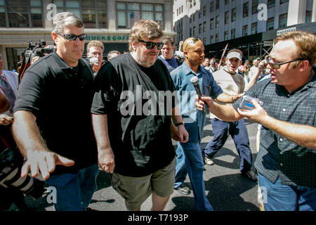 Dokumentarfilmer und Autor Michael Moore ist von Bodyguards während der Teilnahme an einer Demonstration während der Republican National Convention in New York begleitet. Links von Moore, shock Jock und Verschwörungstheoretiker Alex Jones versucht Moore zu interviewen. Stockfoto