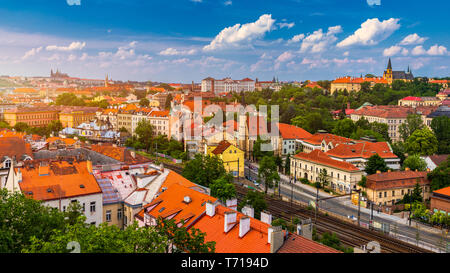 Blick auf die Prager Burg über den roten Dach von Vyšehrad Bereich bei Sonnenuntergang leuchten, Prag, Tschechische Republik. Malerischer Blick auf Prag, Prager Burg und Petrin Stockfoto