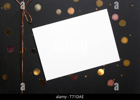 Hinweis oder Grußkarte, golden Konfetti und Schleife auf Black box Hintergrund. Geschenk Idee Stockfoto