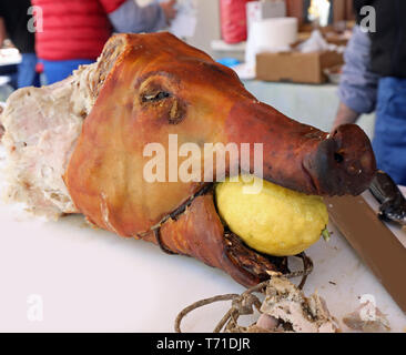 Schweinebraten mit einer gelben Zitrone in den Mund während eines Festivals party Stockfoto