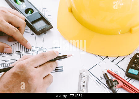 Architekten arbeiten mit Construction Tools und Helm Sicherheit auf Holz- Hintergrund Stockfoto