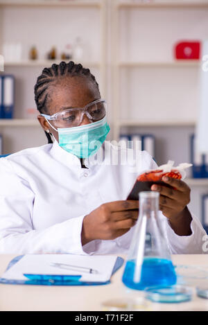 Junge schwarze Chemiker im Labor arbeiten Stockfoto