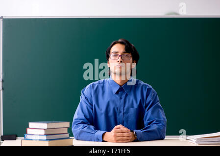 Junge männliche Lehrer vor der Tafel Stockfoto